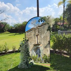 an old building with a sign on it in the grass