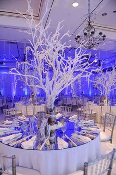 the table is set with white linens and blue lighting for an elegant wedding reception