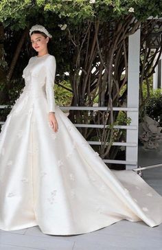 a woman in a white wedding dress standing outside