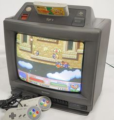 an old nintendo game system with two controllers and a video game on the tv screen