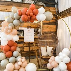 an assortment of balloons are on display in a room with wooden walls and flooring