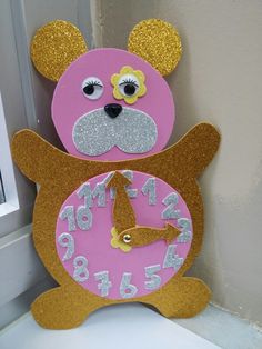 a pink and gold clock with a bear face on it