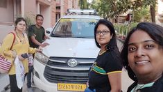 three people standing in front of a white van