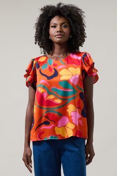 Feel the vibes of tropical paradise when you’ve got the Serene Floral Deja Satin Ruffle Blouse. A soft satin floral top features a higher round neck and layered tulip sleeves that frame a classic fit bodice. Wear it with shorts and sandals to create a fun look. - Satin- Tulip flutter sleeves- Keyhole- Lined- Color: Orange MulSize + Fit - Model is 5'11" and wearing size XS- Measurements taken from size S - Chest: 19"- Length: 25" Fabric Self:100%Polyester, Lining:97%Polyester 3%Spandex Style Numb Tulip Sleeve, Halter Jumpsuit, Chiffon Blouse, Maxi Wrap Dress, Fitted Bodice, Flutter Sleeve, Round Neck, Bodice, Floral Tops