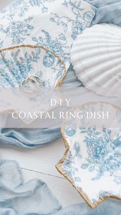 two seashells with blue and white flowers on them are sitting next to the words diy coastal ring dish