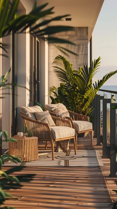 two wicker chairs sitting on top of a wooden deck next to plants and water