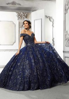 Pure elegance is this gorgeous Quinceanera ball gown with an off-the-shoulder, sweetheart neckline. 89313, is a Morilee Vizcaya creation with sparkling crystal beading on a blooming floral patterned, glitter tulle skirt. The Navy tone makes is perfect for a Winter Wonderland theme! Come check us out at Terry Costa! Quinceanera Dresses Damas, Quinceañera Dresses, Damas Dresses, Blue Ball Gown, Quinceñera Dresses, Blue Quince, Rose Gold Dress, Quinceanera Dresses Blue, Pretty Quinceanera Dresses