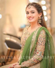 a woman in a green sari is posing for the camera