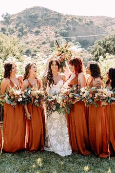 a group of women standing next to each other on top of a lush green field