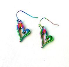 Elevate your accessory collection with our charming Small Heart Shaped Earrings Dangle, a perfect expression of affection. 🔸 Heart drop earrings length: approx. 1.5 x 0.6 inch = 3.8 x 1,5cm 🔸 Laser cut titanium rainbow heart earrings perfectly fashionable to complete any colourful outfit. 🧡 Crafted with care, these heart-shaped earrings showcase a mesmerizing rainbow titanium finish, creating an iridescent effect that's truly eye-catching. Hypoallergenic materials ensure comfortable wear for Cheap Multicolor Heart Charm Earrings, Cheap Cute Multicolor Heart Earrings, Cheap Multicolor Heart Dangle Earrings, Cheap Multicolor Dangle Heart Earrings, Cheap Rainbow Heart-shaped Jewelry, Titanium Earrings, Heart Shaped Earrings, Heart Drop Earrings, Rainbow Heart