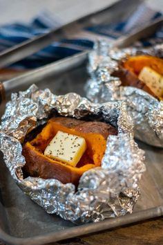 some food is sitting in tin foil on a tray