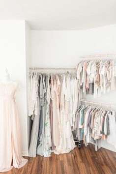 a closet with clothes and dresses hanging on the wall