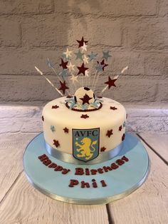 a birthday cake decorated with stars and a crest