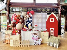 a farm themed birthday party with balloons and decorations on the walls, including a barnyard