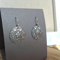 Inspired by an antique buttons, these silver mandala earrings are handmade. Each disc is carefully formed, torch fired and then hand polished in my studio. Sterling silver ear wires are also handmade. 1" length including ear wires .75" wide at widest point Buy with confidence, as all jewelry items are securely packaged and shipped promptly upon payment. Shop now and enjoy free shipping and gift wrap! Please browse my shop for more unique finds: www.bonnierosejewelry.com Additional Information: > Handmade Medallion Sterling Silver Earrings, Handmade Antique Silver Round Earrings, Silver Sterling Silver Medallion Earrings, Star Mandala, Mandala Earrings, Silpada Jewelry, Rose Jewelry, Antique Buttons, Hand Made Jewelry