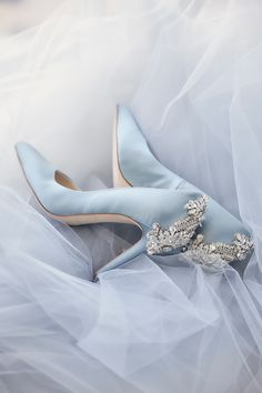 a pair of blue wedding shoes on top of white tulle skirted dress material