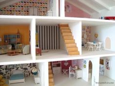 a doll house with all the furniture and accessories in it, including stairs to the second floor