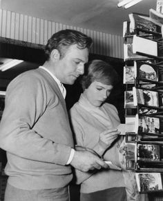 a man and woman looking at magazines in a store