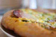 a close up view of a pizza with cheese and bacon on it's crust