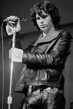 a black and white photo of a man holding a microphone