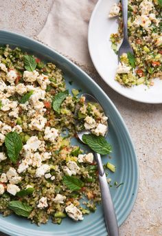 a plate full of food next to a bowl filled with rice and minty greens