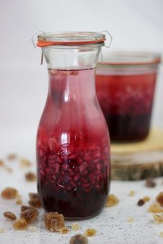 two jars filled with liquid sitting on top of a table