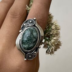 Handmade sterling silver ring with natural moss agate stone. Green gemstone ring in filigree technique and vintage style. Artisan jewelry made in Armenia by the Shahinian family. The ring`s band is adjustable and comfortable both to wear and give as a gift to those who don`t know the exact size of the finger. This ring is the perfect gift idea also for the ones who love unique, modern, and high-quality jewelry. ⦿We can also make matching earrings, pendants, and bracelets. For more details, just Bohemian Oval Jade Jewelry, Moss Agate Ring With Natural Stones, Bohemian Agate Ring With Large Stone, Handmade Adjustable Oval Emerald Ring, Handmade Oval Moss Agate Ring, Oval Jade Ring With Natural Stones, Oval Emerald Ring With Natural Stones In Sterling Silver, Handmade Silver Rings With Moss Agate, Handmade Silver Moss Agate Rings