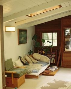 a living room filled with furniture next to a window and bookshelf on the wall