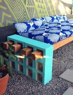 a bench made out of wooden blocks in front of a wall