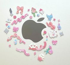 the apple logo is surrounded by many different types of stickers and magnets on a white surface