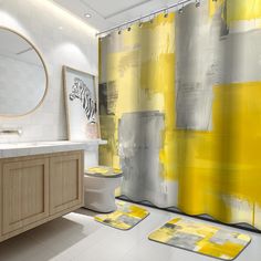 a bathroom with yellow and gray shower curtain, rugs and sink in front of it