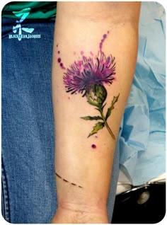 a woman's arm with a purple flower on it