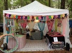 a tent that is set up in the woods for an outdoor party with decorations on it