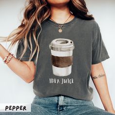 a woman wearing a t - shirt that says idea juice with a cup of coffee on it