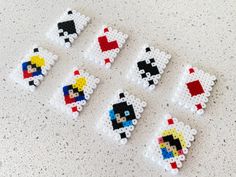 six pixel art magnets are arranged on a table