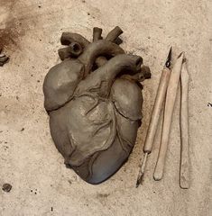 a heart shaped clay sculpture next to some tools