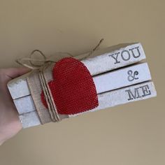 a hand holding two matchesticks with a red heart on it and the words you & me written on them