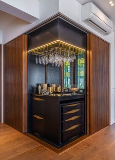 a bar with wine glasses on it in the middle of a room that has wood floors and walls