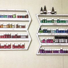 two shelving shelves filled with lots of different colored bottles on top of each shelf