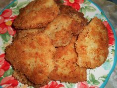 some fried food on a colorful plate with red and green flowers around it, ready to be eaten