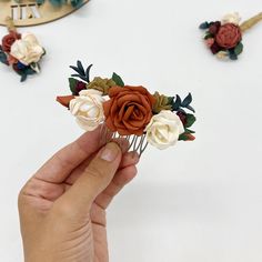 a person is holding some fake flowers in their hand while they are on the table