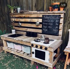 an outdoor kitchen made out of pallets and wooden pallets with chalkboard on the wall