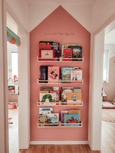 there is a pink wall with books on it