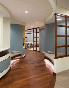 an empty room with wood flooring and blue walls, along with two benches on either side