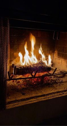 a fire burning in a fireplace with lots of flames