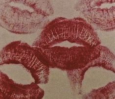 red lipstick drawn on white paper with different shapes and sizes in the middle, surrounded by smaller lips