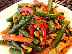 a white plate topped with green beans and red peppers