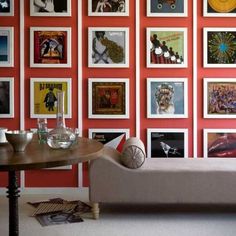 a living room with red walls and pictures on the wall behind the couch is a coffee table