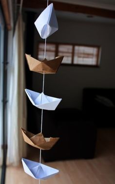 a mobile with paper boats hanging from it