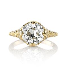 a yellow gold engagement ring with an oval cut diamond in the center and filigrees around the band